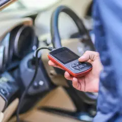 Diagnostyka Renault: ręka trzyma skaner OBD, sprawdzając błędy, np. DTC B1267.
