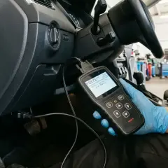 Mechanik w rękawiczce diagnostycznej sprawdza kod błędu P0171 w samochodzie.