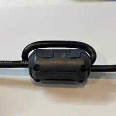 Czarny kabel z nawiniętym na niego ferrytem TDK.