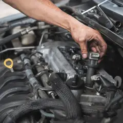Mechanik wymienia cewkę zapłonową. Objawy awarii cewki zapłonowej mogą być różne, np. nierówna praca silnika.