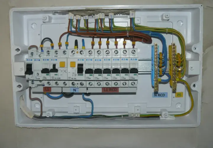 Instalacja elektryczna z bezpiecznikami B16. Widoczne wyłączniki nadprądowe, RCD, listwy zaciskowe N i PE.