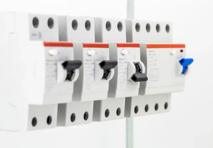 Szukasz informacji, jaki bezpiecznik do 5kW? Na zdjęciu widać rzędy wyłączników nadprądowych, które chronią instalację elektryczną.