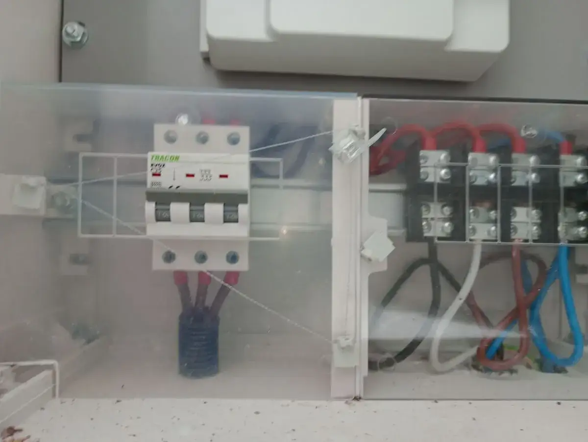 Tracon bezpiecznik c25 3 fazowy, chroniący instalację przed przeciążeniem. W skrzynce widać przewody fazowe i neutralny.