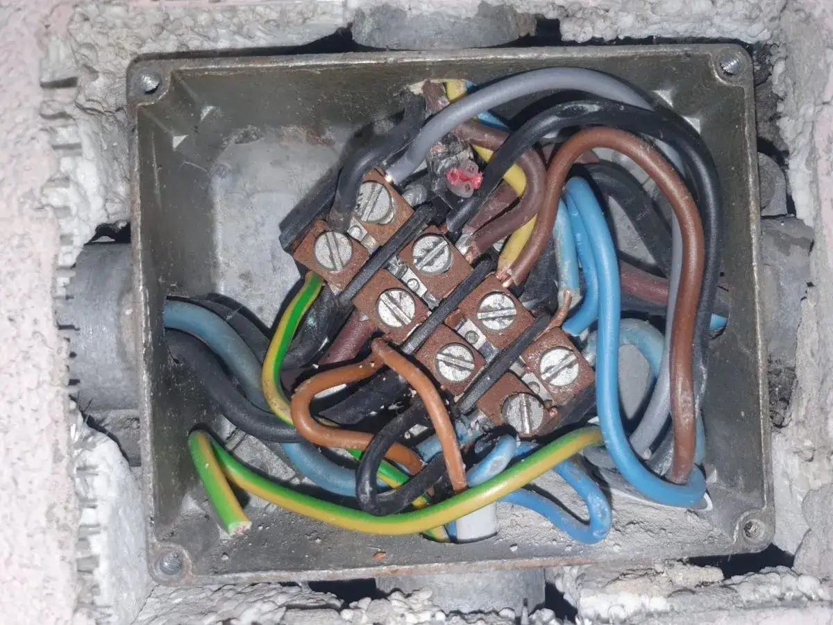 W tej puszce elektrycznej widać plątaninę przewodów. Czy można łączyć przewód neutralny z ochronnym? Instalacja wygląda niebezpiecznie.