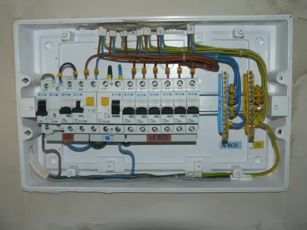Instalacja elektryczna z bezpiecznikami B16. Widoczne wyłączniki nadprądowe, RCD, listwy zaciskowe N i PE.